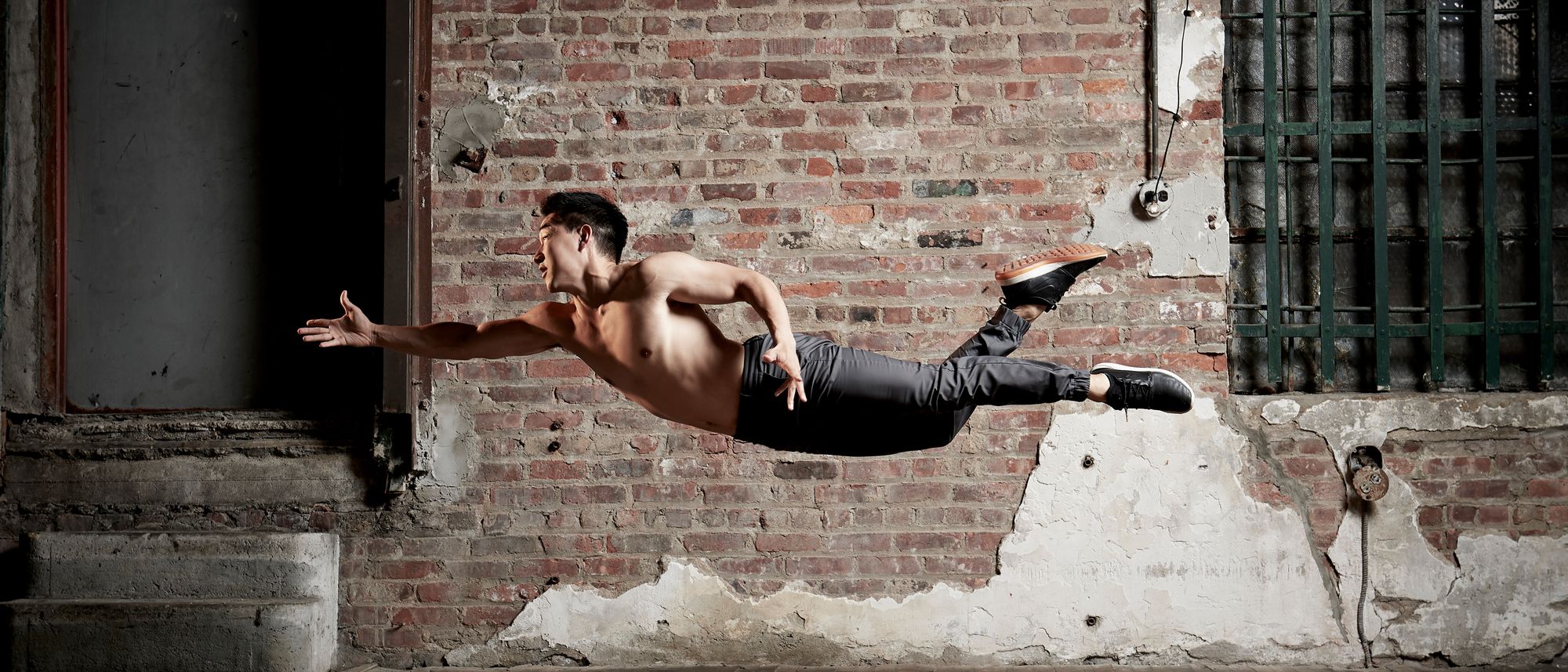 Alex Wong flying horizontally across a brick loft