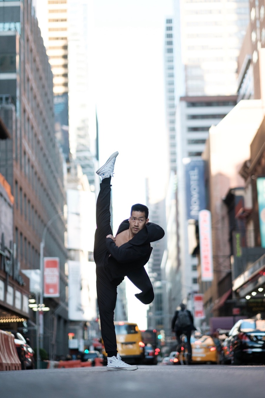 Alex Wong in a standing split on a busy Midtown street
