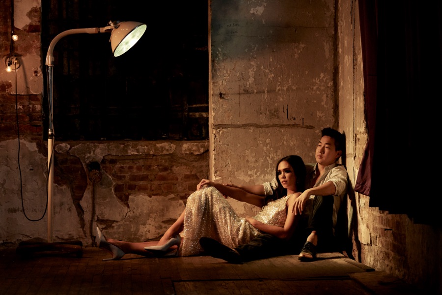 Alex Wong and a woman reclining on the floor of a dim loft
