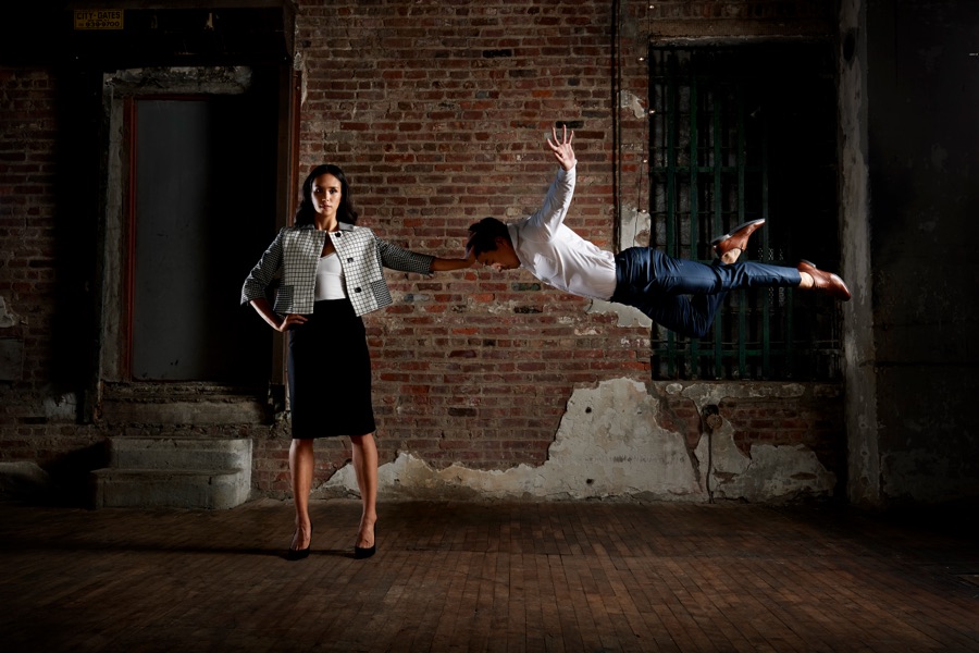 Alex Wong flying past a woman standing in a brick loft
