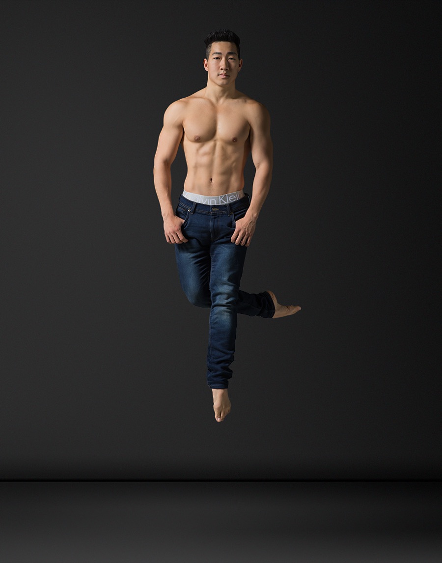 Alex Wong jumping in jeans against a dark backdrop