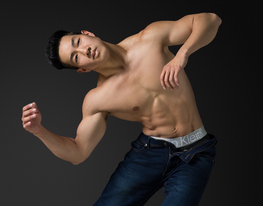 Alex Wong twisting his torso against a dark backdrop