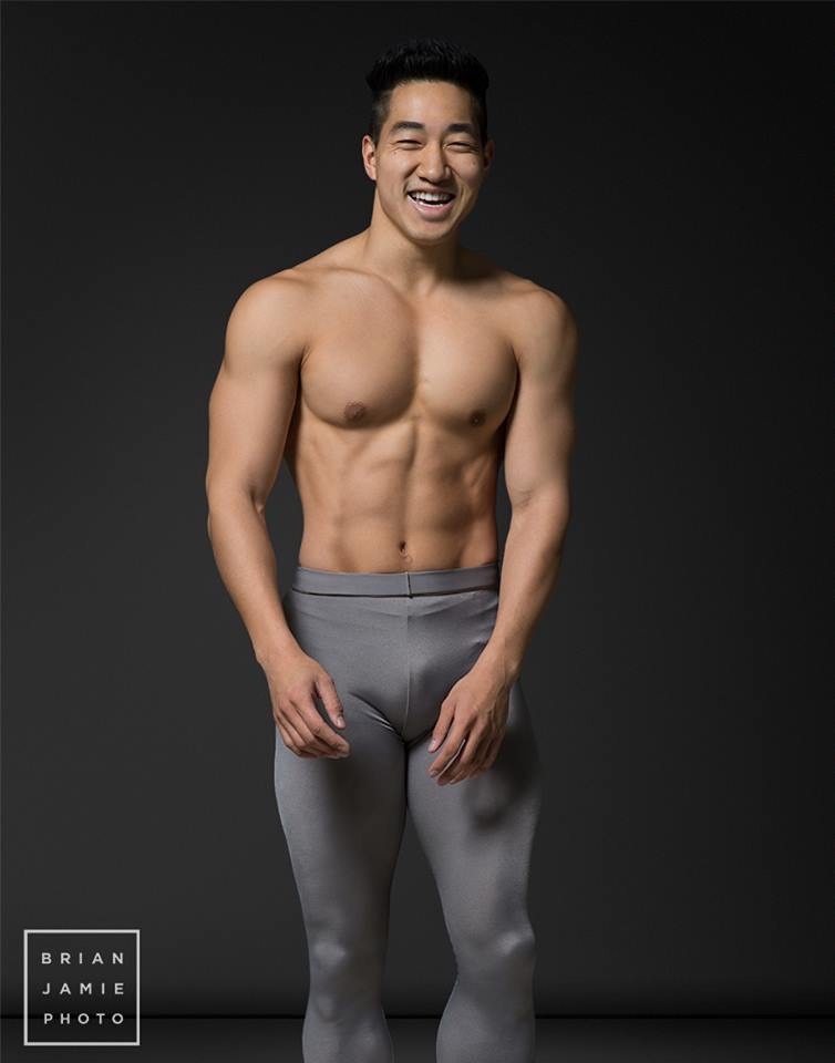 Alex Wong laughing in grey tights against a dark backdrop