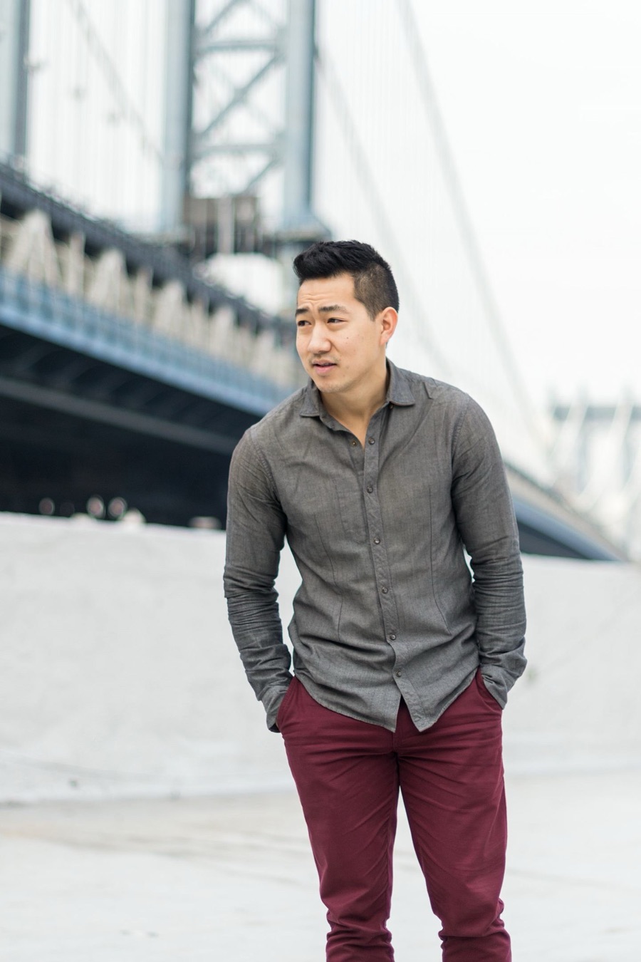 Alex Wong in a grey shirt beneath a city bridge